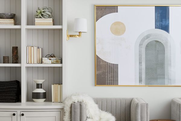 带有白色书架衬里墙壁的起居室，已装饰有书籍和小玩意