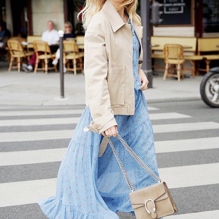 一个穿着蓝色连衣裙一个女人和一个卡其色外套